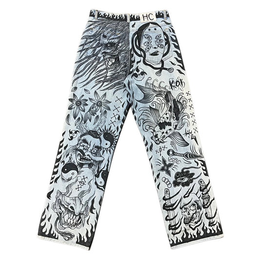 Pants with black and white tattoo-style designs on a white background