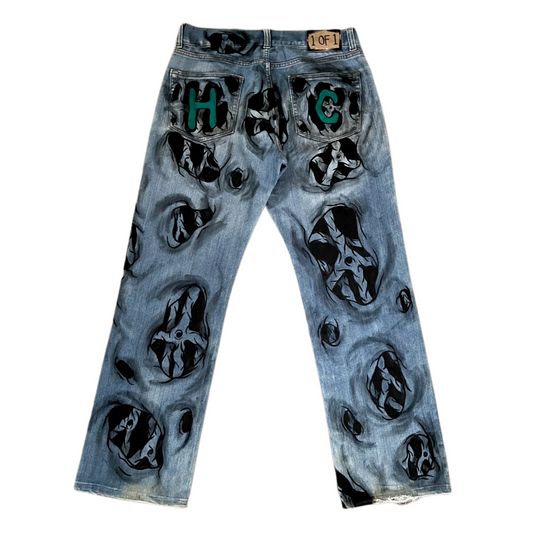 Blue jeans with black and green designs on a white background