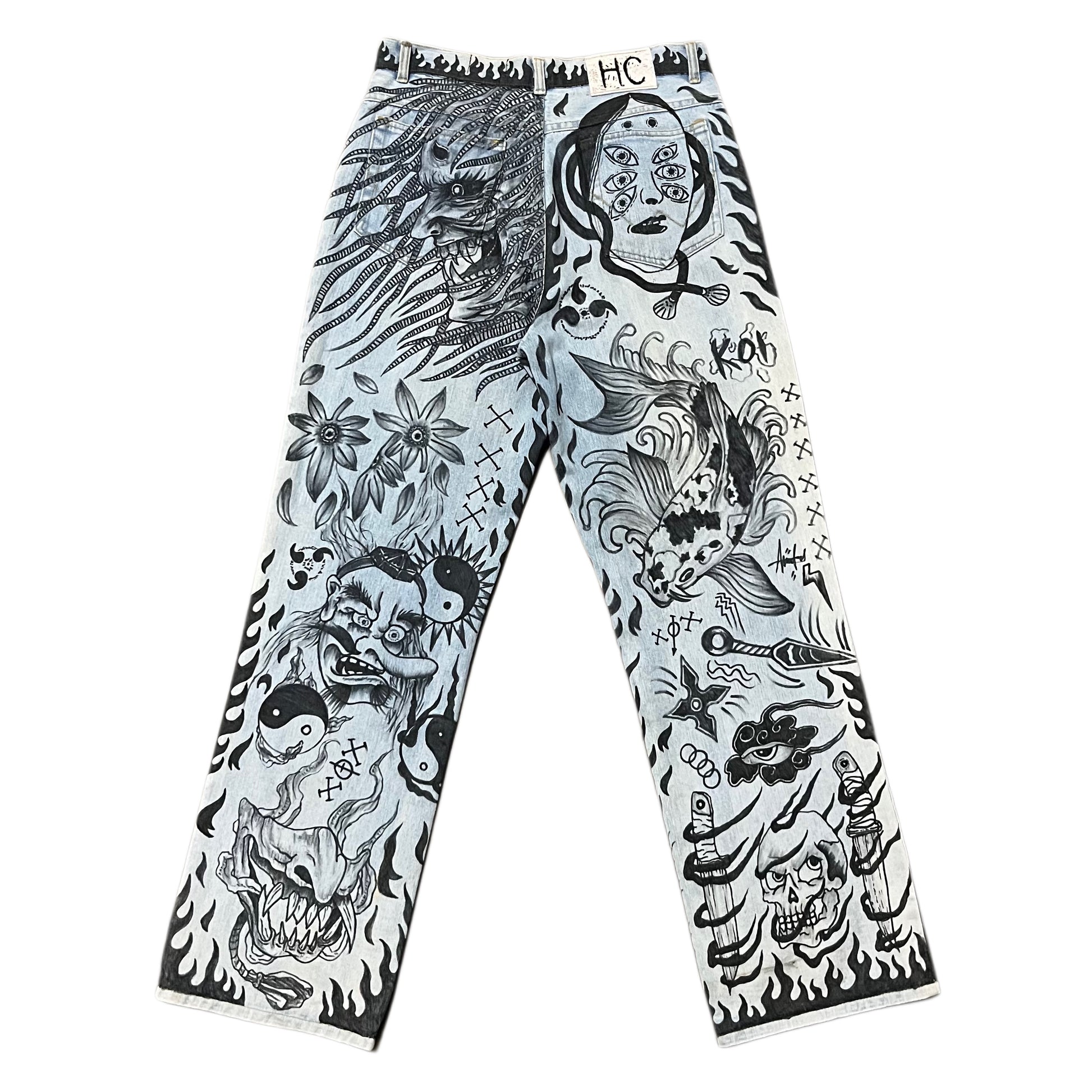 Pants with black and white tattoo-style designs on a white background
