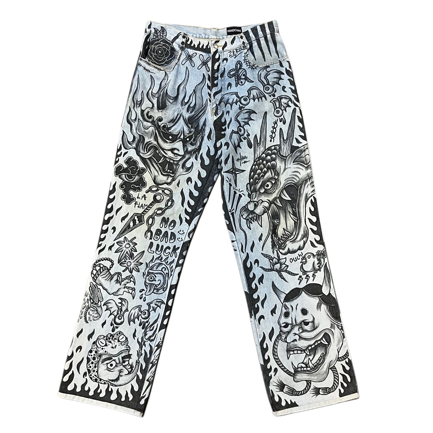 Pants with black and white tattoo-style designs on a white background