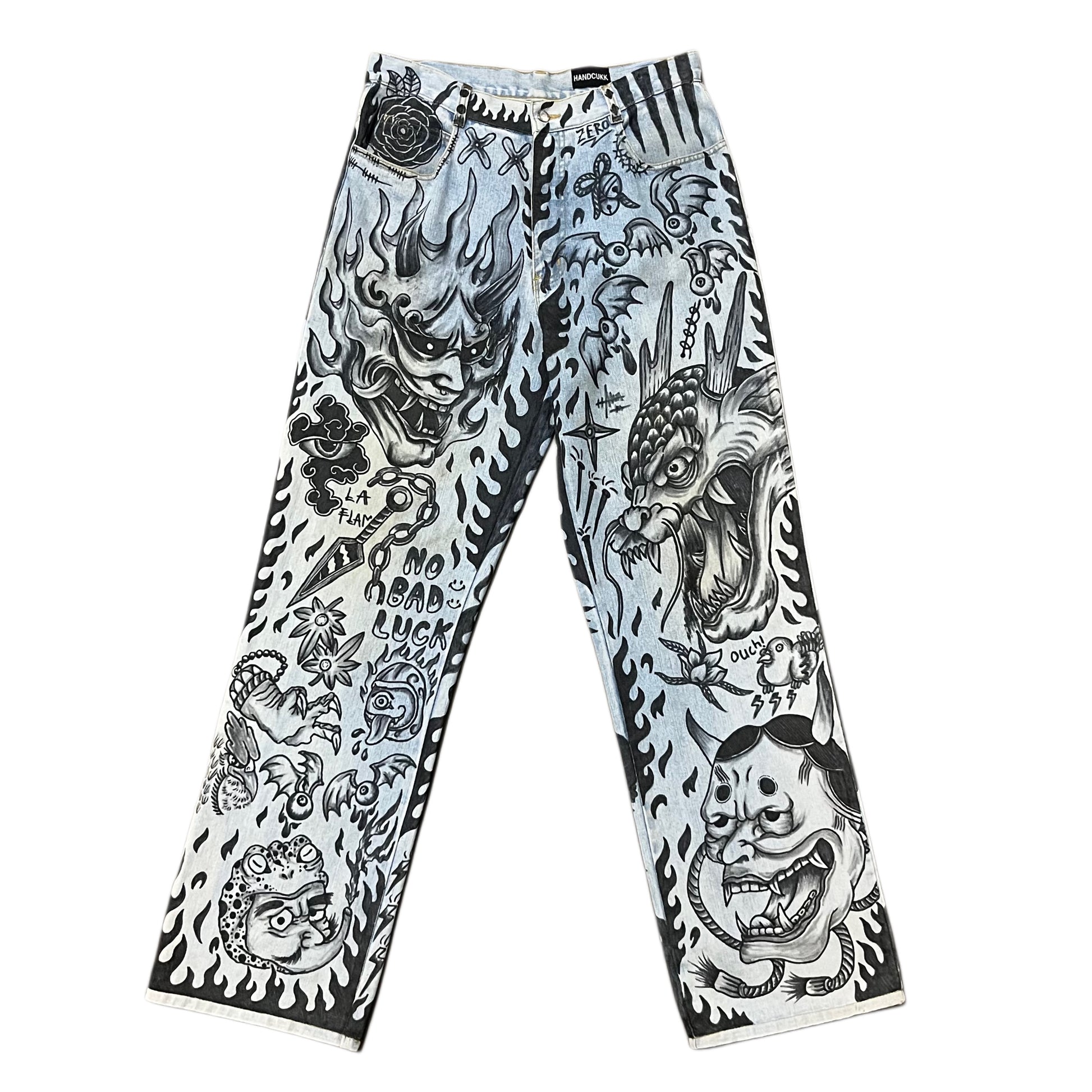 Pants with black and white tattoo-style designs on a white background