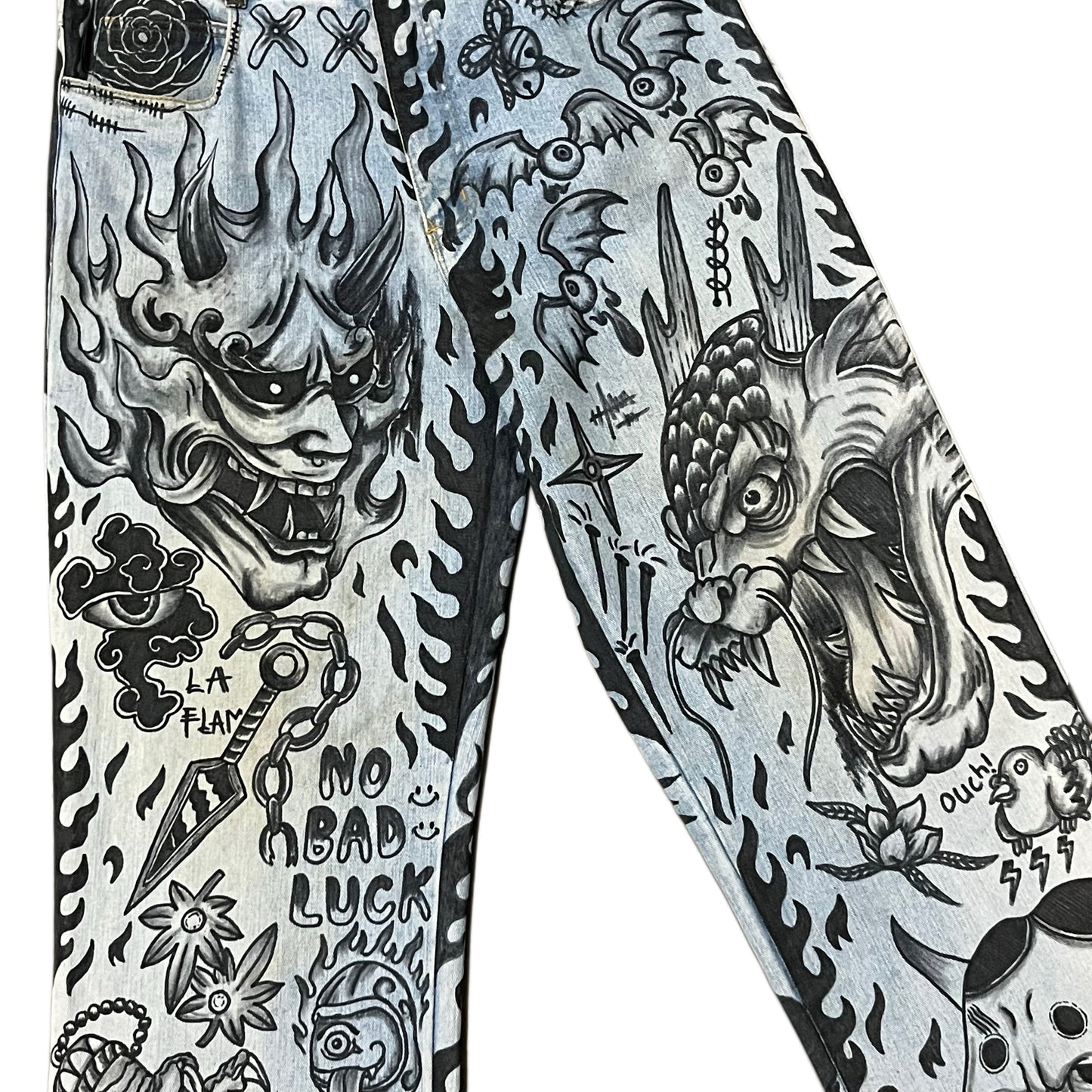 Tattooed jeans with various designs including a dragon and text on a white background