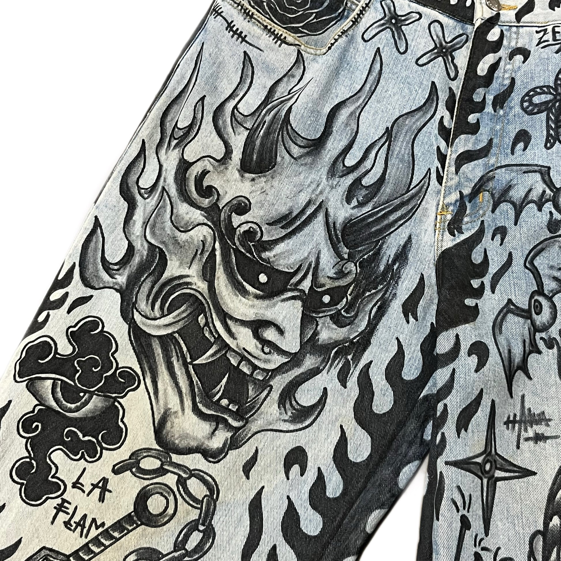 Close-up of a denim jacket with black and white tattoo-style designs.